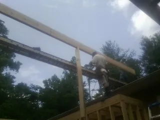 Carpenter setting a ridge beam over a new addition frame — Ice Dam Removal by Roofing Brothers in Maury