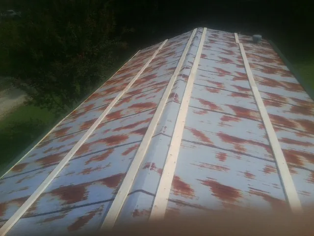 Rusted metal roof panels with new wood purlins before replacement — Storm Damage Roof Repair in Maury by Roofing Brothers