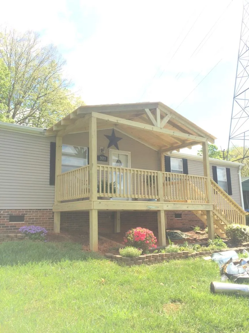 New gabled porch roof and deck railing added to a ranch home in Maury